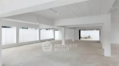 Spacious open-plan interior with white walls and large windows, ideal for customization.