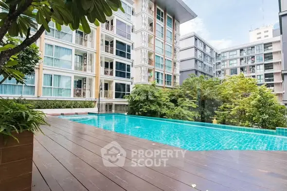 Modern apartment complex with a stunning outdoor pool and lush greenery.