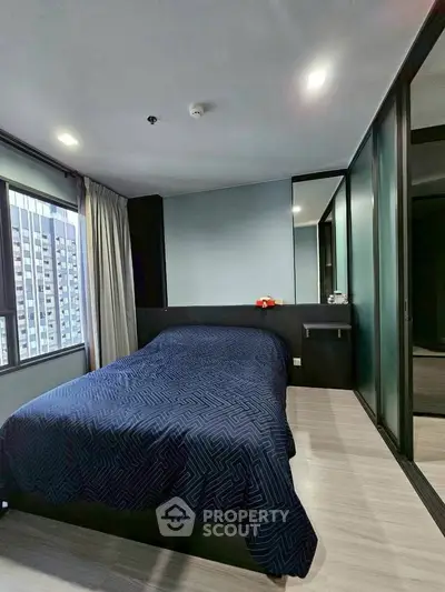 Modern bedroom with city view, featuring sleek design and ample natural light.