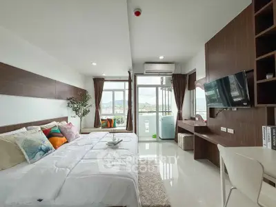 Modern bedroom with balcony and scenic view, featuring stylish decor and natural light.
