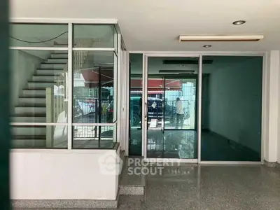 Spacious commercial property with glass doors and staircase, ideal for business setup.