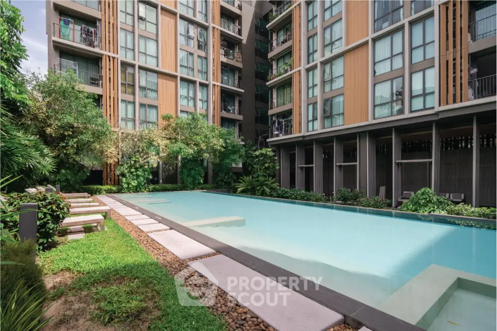 Modern condominium with serene pool and lush greenery, perfect for urban living.
