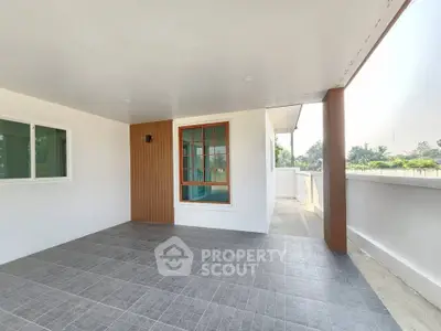 Spacious balcony with modern design and large windows, perfect for relaxation and outdoor enjoyment.