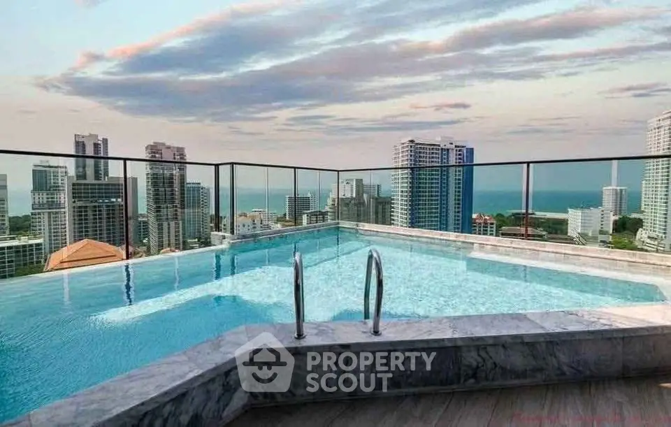 Stunning rooftop pool with panoramic city and ocean views in luxury high-rise building.