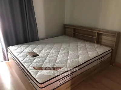 Spacious bedroom with wooden bed frame and natural light