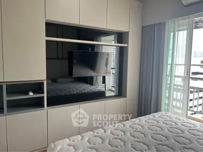 Modern bedroom with built-in TV and balcony view
