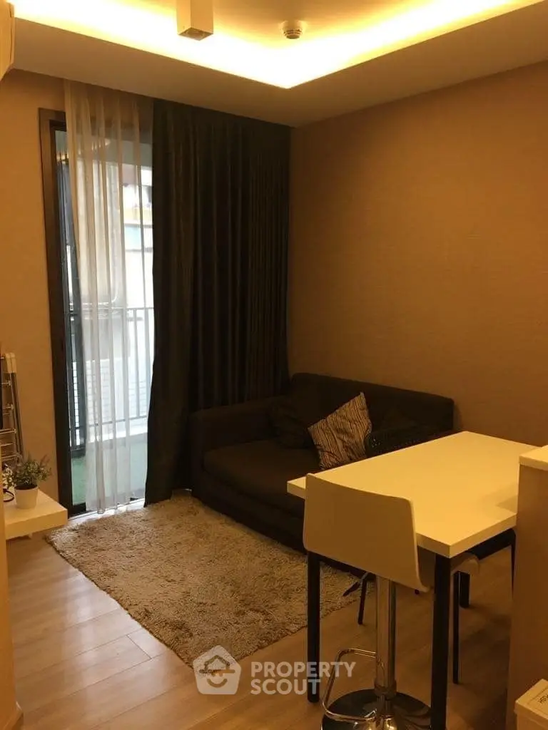 Cozy living room with modern decor and balcony access in a stylish apartment.