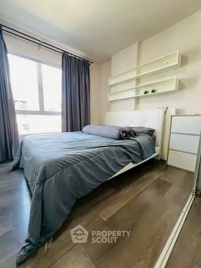 Modern bedroom with sleek design and natural light, featuring hardwood floors and minimalist decor.