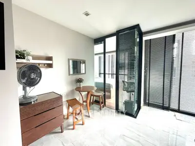 Modern interior with glass partition, stylish furniture, and natural light in a contemporary apartment.