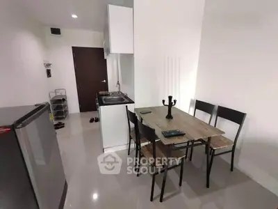 Modern compact kitchen and dining area with sleek design and minimalist furniture.