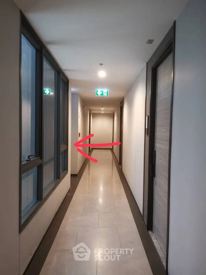 Modern apartment corridor with sleek design and emergency exit signs