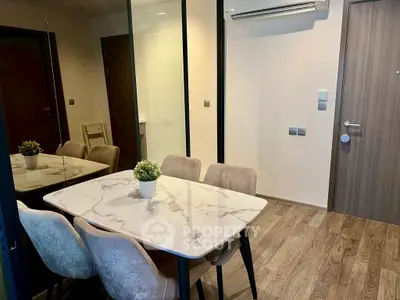Modern dining area with marble table and stylish chairs in a cozy apartment setting.