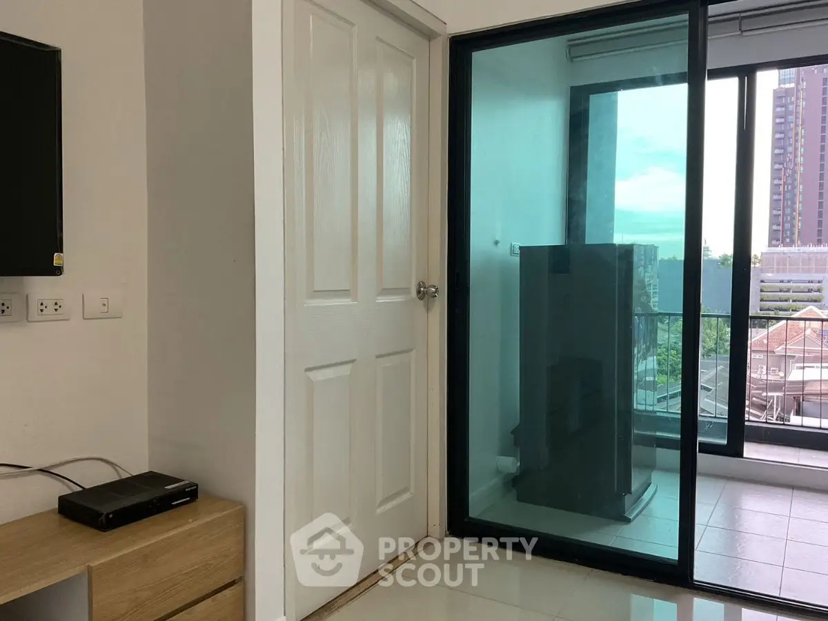 Modern apartment with balcony and city view, featuring sleek interior design and ample natural light.