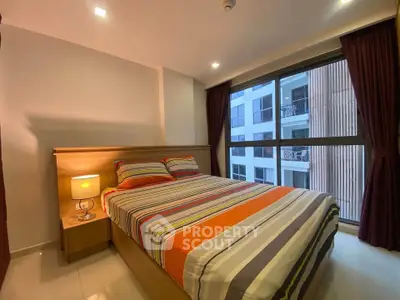 Cozy bedroom with large window and modern decor in urban apartment