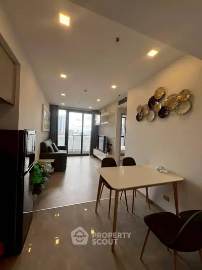 Modern living room with open layout and stylish decor, featuring a cozy seating area and dining space.