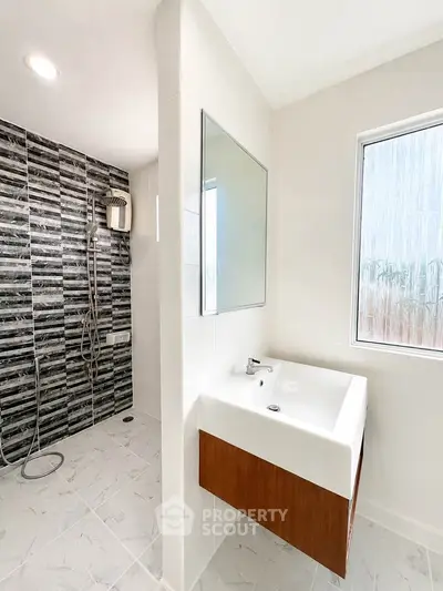 Modern bathroom with sleek shower and stylish sink in contemporary home.