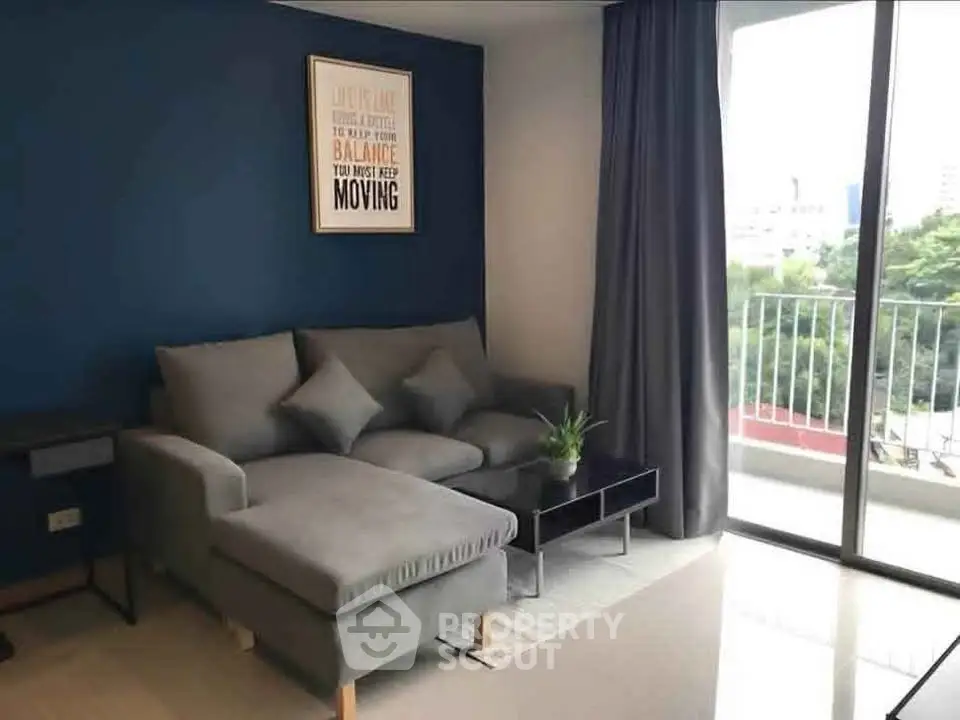 Modern living room with stylish gray sofa and balcony view