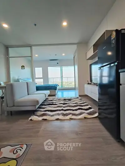 Modern open-plan living room with stylish decor and large windows offering a scenic view.