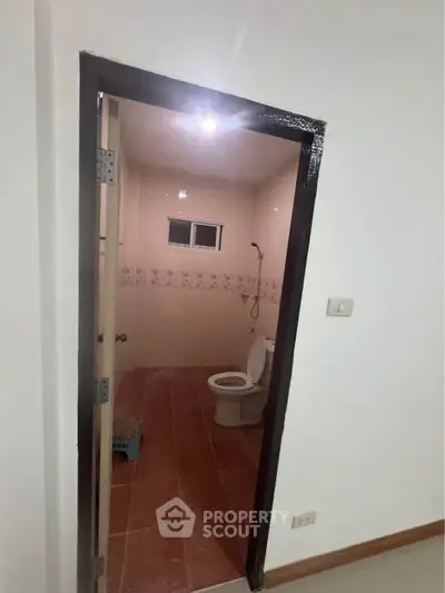 Cozy bathroom with tiled floor and shower, ideal for compact living spaces.