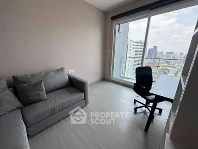 Modern living room with city view, featuring a cozy gray sofa and sleek desk by the window.