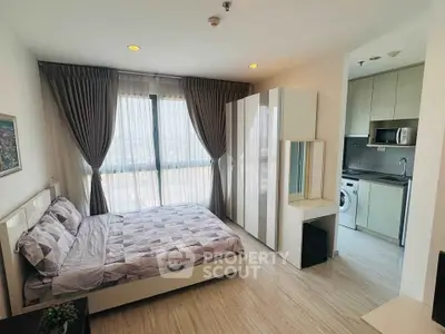 Modern bedroom with stylish decor and integrated kitchen appliances in a bright apartment.