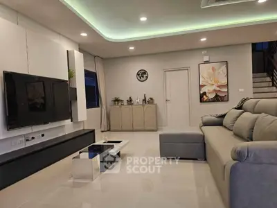 Modern living room with sleek furniture and ambient lighting, perfect for relaxation and entertainment.