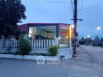 Charming corner property with modern glass facade and cozy outdoor space.