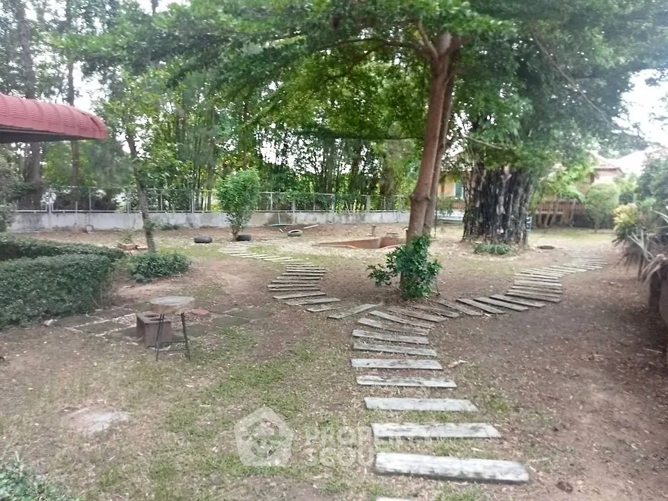 Serene garden oasis with stepping stone path, lush greenery, and mature trees, ideal for peaceful outdoor living and nature enjoyment.