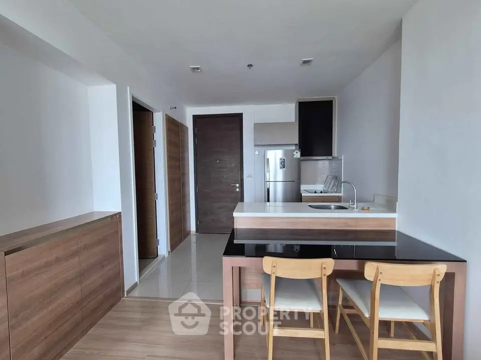 Modern kitchen with sleek design, featuring a breakfast bar and wooden accents, perfect for contemporary living.