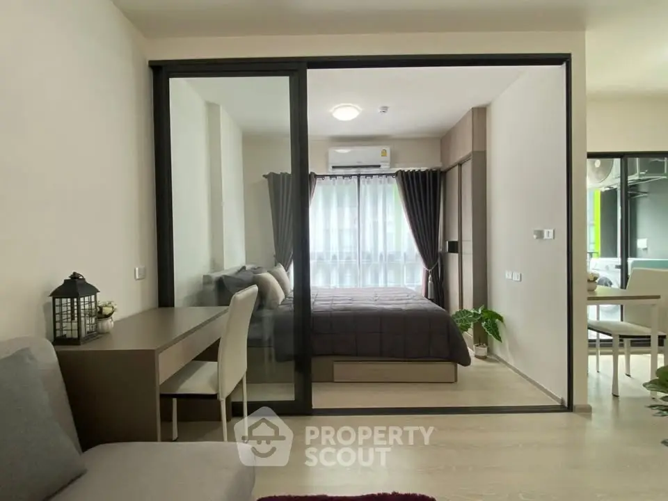 Modern apartment interior with glass partition, cozy bedroom, and stylish living area.