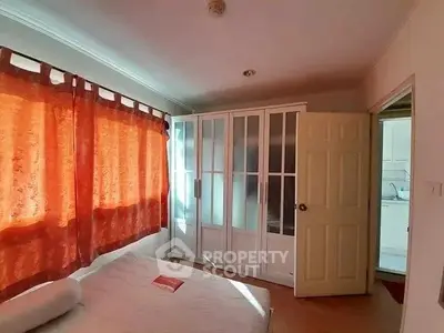 Cozy bedroom with large window and built-in wardrobe, perfect for relaxation.