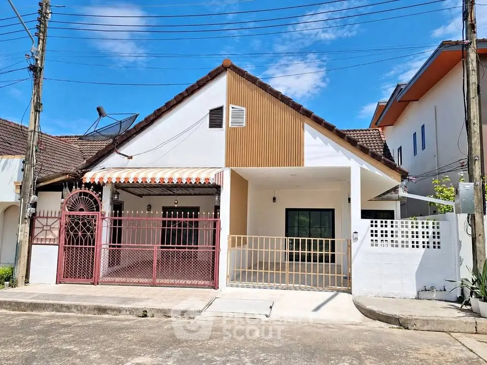 Charming single-story house with gated entrance and modern facade in a suburban neighborhood.