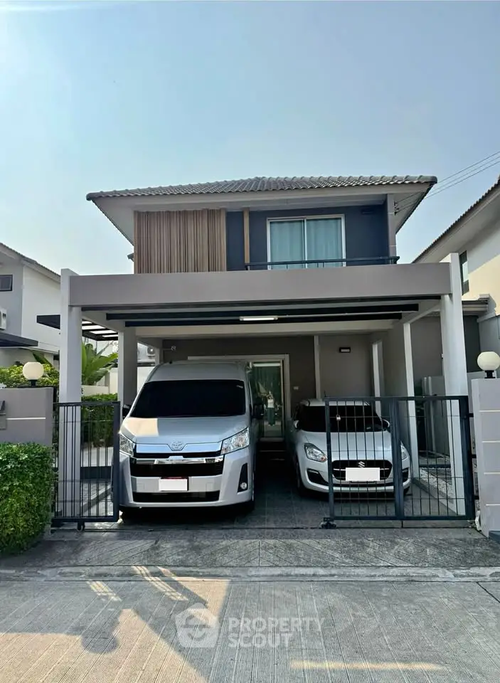 Modern two-story house with spacious driveway and parked cars