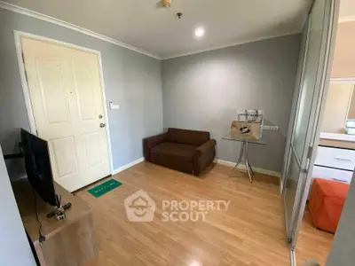 Cozy living room with wooden flooring, compact sofa, and modern decor in a stylish apartment.