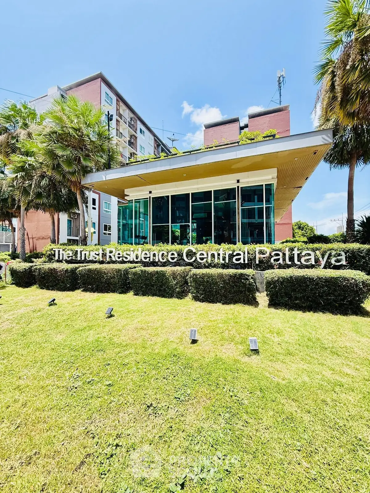 Modern building exterior with lush greenery at The Trust Residence Central Pattaya.