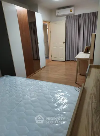 Modern bedroom with wooden flooring and sleek furniture design