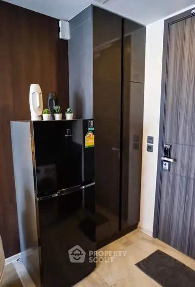 Modern kitchen corner with sleek black fridge and stylish cabinetry