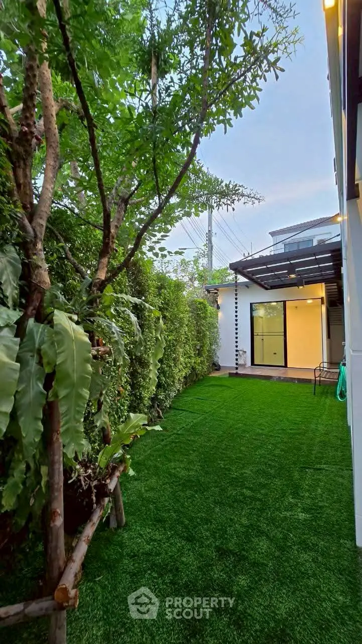 Charming garden with lush greenery and modern patio, perfect for relaxation.
