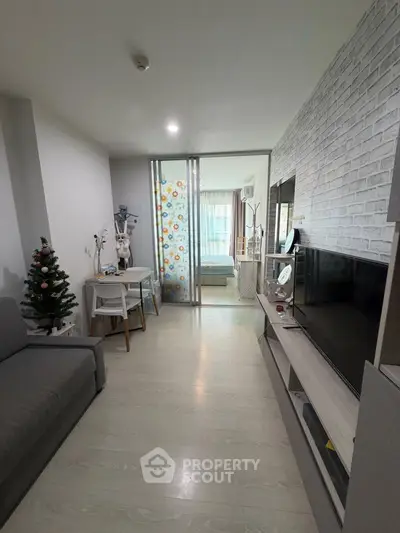 Modern living room with stylish decor and sliding glass doors leading to a cozy bedroom.