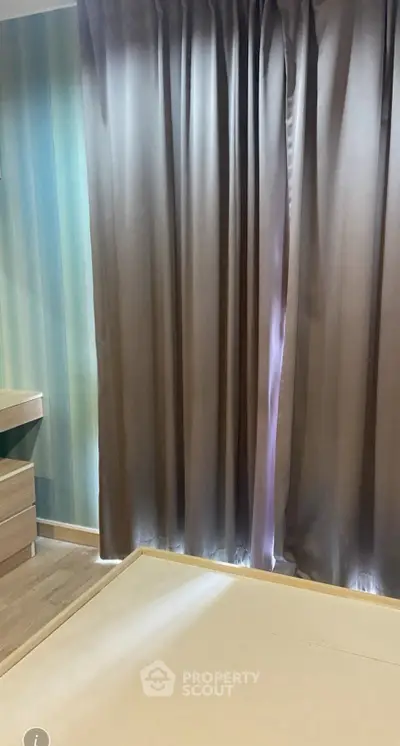 Cozy bedroom with elegant curtains and wooden flooring, perfect for a serene retreat.