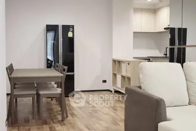Modern open-plan living room with dining area and sleek kitchen in a stylish apartment.