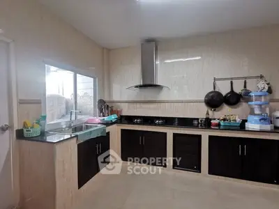 Spacious modern kitchen with sleek cabinetry and gas stove, perfect for culinary enthusiasts.
