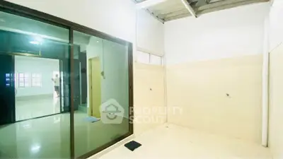 Spacious interior with tiled flooring and large glass sliding doors, ideal for modern living.