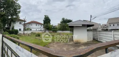 Spacious residential plot with lush greenery and charming gazebo, ideal for custom home building.