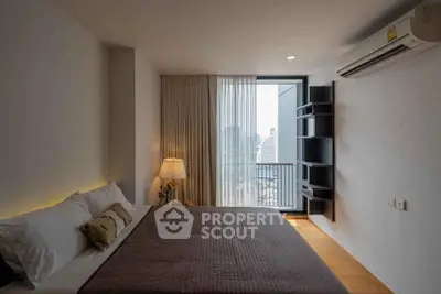 Modern bedroom with city view, featuring a cozy bed and stylish decor.