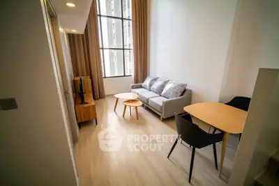 Modern living room with high ceilings and large window in a stylish apartment.