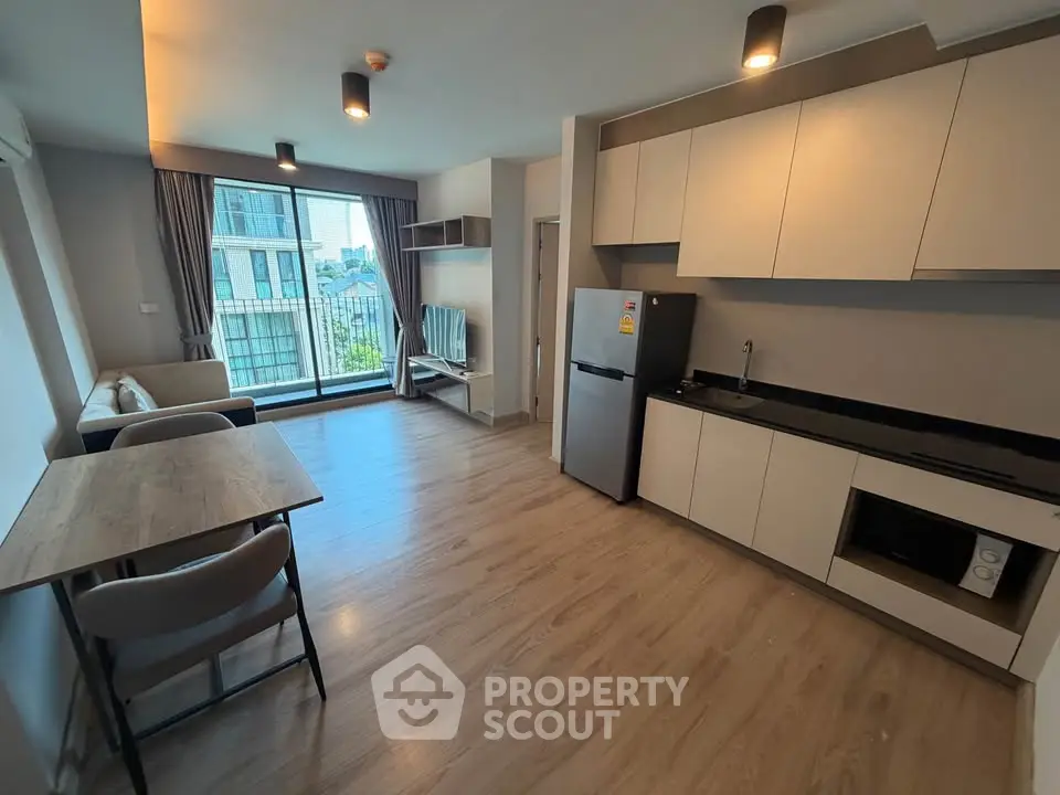 Modern open-plan living room and kitchen with balcony view