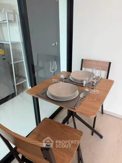 Cozy dining area with wooden table and chairs, perfect for intimate meals in a modern apartment.