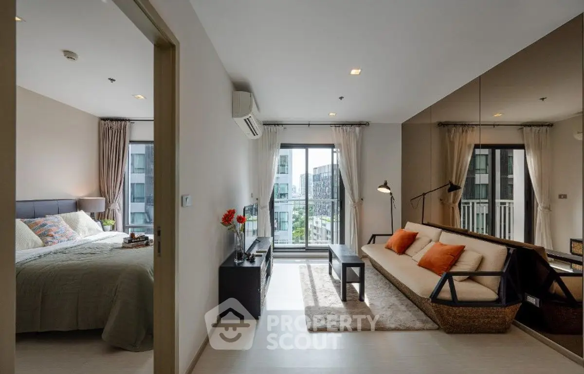 Modern apartment with spacious living room and cozy bedroom, featuring large windows and stylish decor.