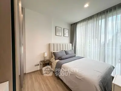 Modern bedroom with large windows and stylish decor in a high-rise apartment.